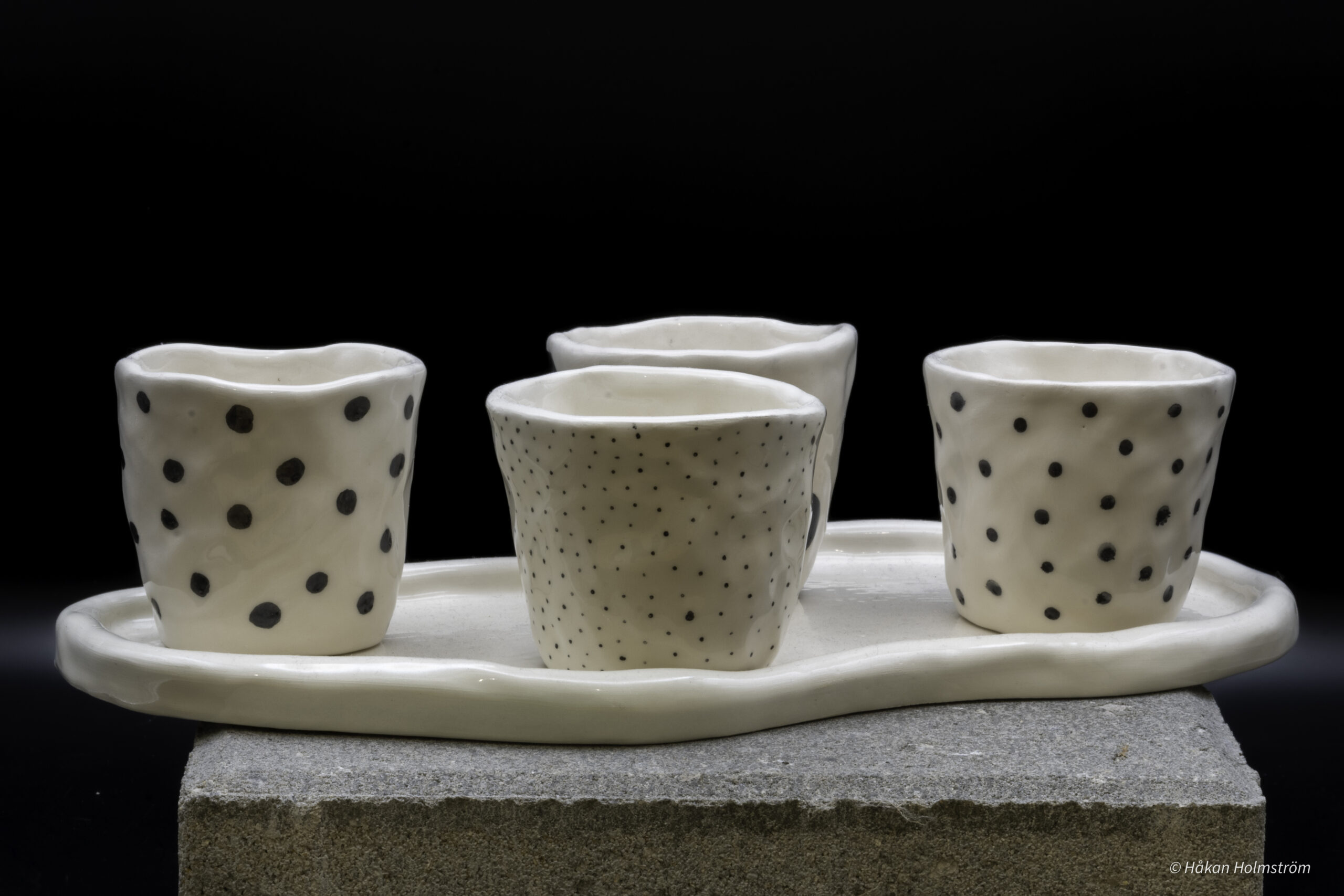 Fyra espresso-muggar på fat